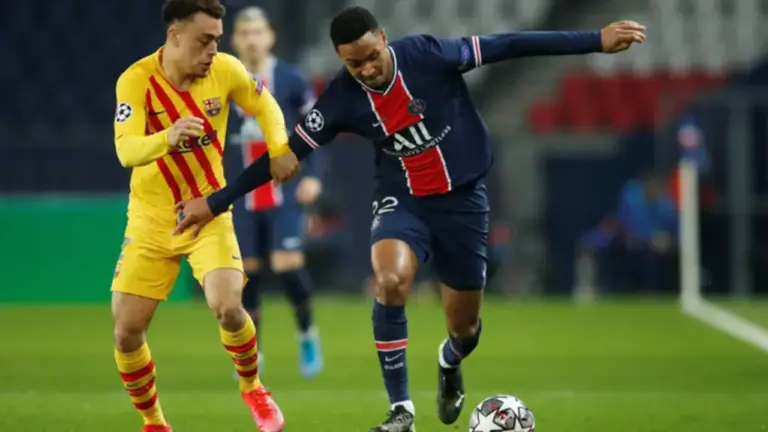 Pemain Paris Saint-Germain Layvin Kurzawa berebuat bola dengan pemain Barcelona Sergino Dest